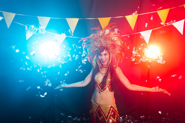 Carnival, dancer and holiday concept - Portrait of a sexy female in a colorful sumptuous carnival feather suit. Nightlife of female dancer