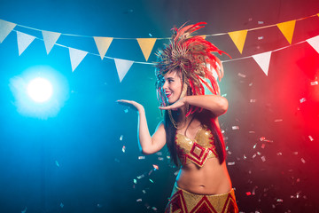 Carnival, dancer and holiday concept - Portrait of a sexy female in a colorful sumptuous carnival feather suit. Nightlife of female dancer