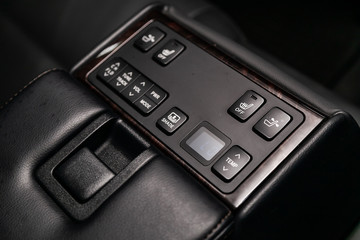 Close-up on the shade lock, seat heatting, seat adjustment , parking radar,Temperature regulator  switch control buttons,  automatic adjust level dashboard. modern car interior: parts, buttons, knobs.