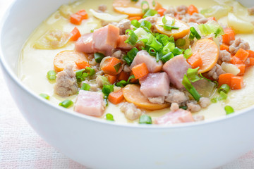 Steamed egg custard cuisine in a white bowl with minced pork, sausage and bacon.  Or Only with egg, water, salt and some sesame oil, you can make this super smooth custard at home.