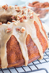 Sweet potato and pecan nuts pound cake with caramel icing, vertical closeup