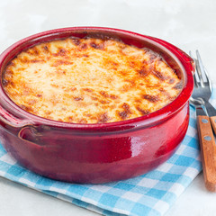 Greek dish moussaka made in  traditional ceramic pot, square format