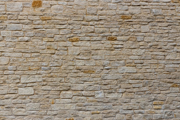 Modern limestone wall with layers of thin stone blocks