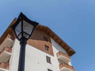 Black street lamp on the background of the facade of house