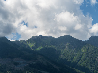 Beautiful green mountains with clouds Rosa Khutor Sochi in summer