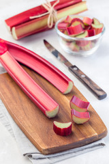 Cutted rhubarb on  wooden board, vertical