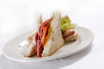 A sandwich club, also called a clubhouse sandwich, is a sandwich of bread, sliced ​​cooked poultry, or fried bacon, lettuce, tomato, and mayonnaise.