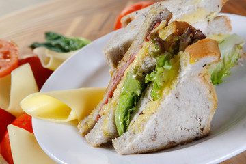 A sandwich club, also called a clubhouse sandwich, is a sandwich of bread, sliced ​​cooked poultry, or fried bacon, lettuce, tomato, and mayonnaise.