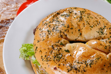 Bagel and croissant of ham, meat and lettuce with cherry tomatoes.