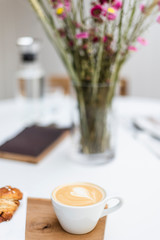 A cup of cappuccino on the table in a Scandinavian-style cafe.