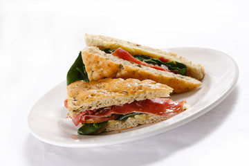 Traditional bread sandwich with serrano ham, cheese and spinach leaves.