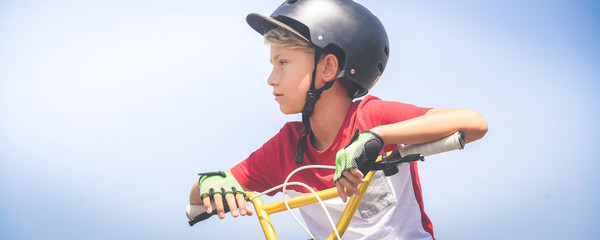 Young cyclist with bmx ready to start. Trendy young boy wearing helmet riding a bicycle looking the...