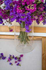 A bouquet of field purple flowers in a glass flask. Vase. Still life. White background.