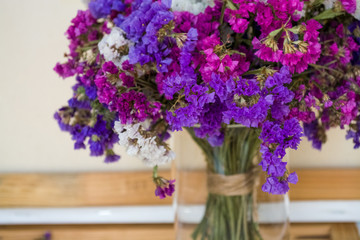 A bouquet of field purple flowers in a glass flask. Vase. Still life. White background.