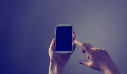 Person holding a white smartphone on a solid background