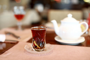 Armud glass with black tea and lemon in cafe