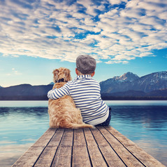 Junge mit Hund blickt in die Berge