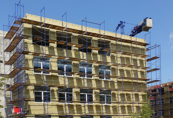 Solid wall insulation with rock wool. Energy efficiency house wall renovation for energy saving. Exterior house wall heat insulation with mineral wool. External wall insulation.
