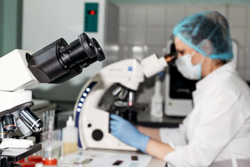 Scientist woman looking through microscope in laboratory Microscope in laboratory, analyzes.