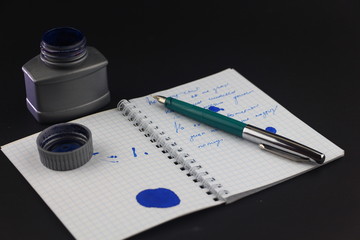 Ink pen on notebook on white background