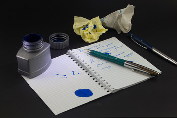 Ink pen on notebook on white background