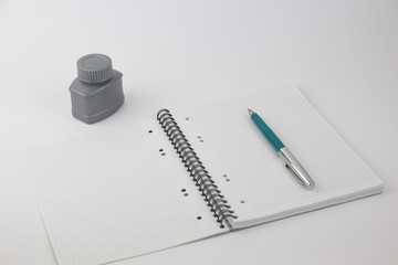 Ink pen on notebook on white background