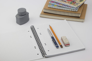 Ballpoint pen with notebook on white table