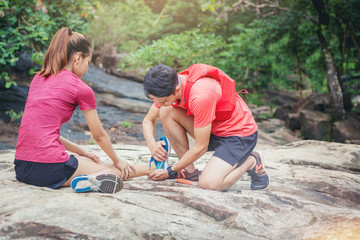 Woman runner has twisted ankle injury for trail runner on mountain take care by her friend
