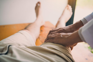 Physiotherapists are using the hands to grip the patient thigh to check for pain and massage in the...