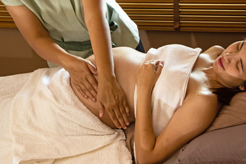 The therapiist massaging pregnant woman,for treat and relax program,at spa therapy