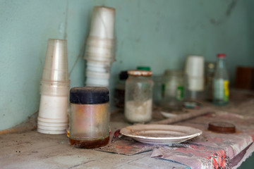 dirty shelf with dishes in an abandoned house