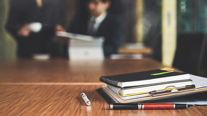 Paper document files and pen business equipment on table in conference room.