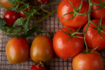 Fototapeta na wymiar Fresh raw tomatoes over wooden background
