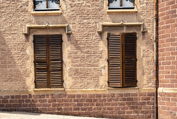 two closed French wooden shutters on side of building