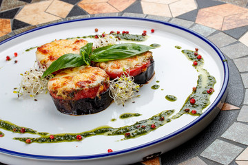 Eggplant with tomatoes, pesto and mozzarella cheese. Italian dish