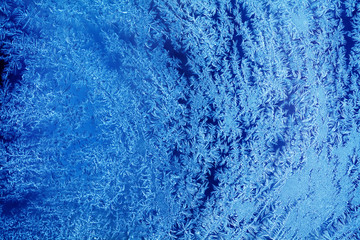 Fototapeta na wymiar Frozen window ice flowers pattern. Christmas season frosty decorative background. macro view
