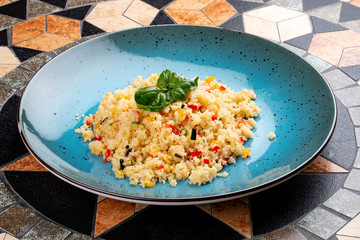 Couscous with vegetables in a ceramic decorative plate