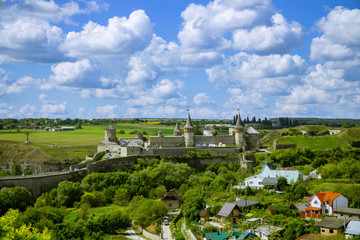 Fototapeta premium Eastern European national UNESCO heritage object in Ukraine medieval castle old landmark top view on green hills in clear weather time with blue sky and white clouds 