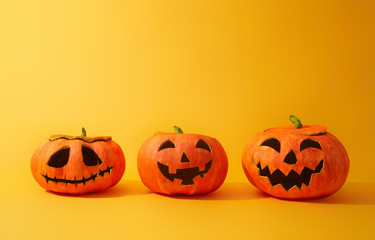 Pumpkins lanterns on yellow background.