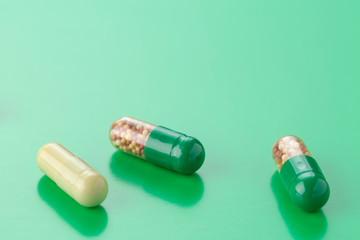 various capsules with antibiotics on a green background