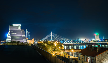 Obraz premium Panoramic view of Riga city with colorful fireworks glowing in the air. Picturesque scene of National library of Latvia, river Daugava and old town. 