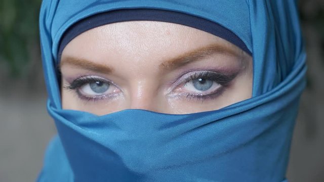 close-up. beautiful blue eyes of arab young woma in traditional islamic cloth niqab