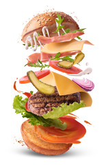 Delicious burger with flying ingredients isolated. - obrazy, fototapety, plakaty