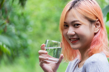 Closeup portrait woman drinking water bottle in nature refresh for her live.