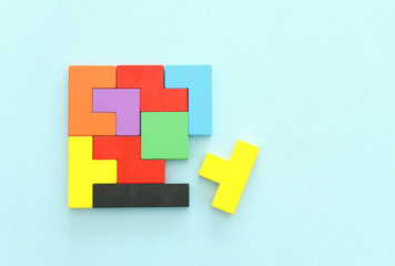 Obraz premium business concept image of a colorful square tangram puzzle, over wooden table