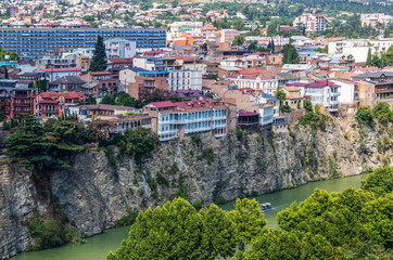 The Georgian Capital of Tbilisi on the cliffs towering above the Mtkvari River that runs from Turkey to the Black Sea - Fascinating buildings and a boat chugging along down below