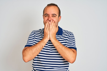 Young man wearing casual striped polo standing over isolated white background laughing and...