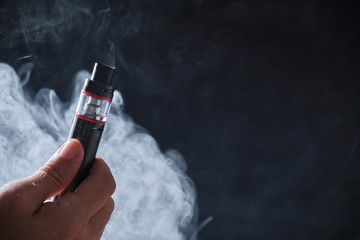 Electronic cogarette vape on a dark background with steam