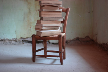 A stack of used books on an old chair