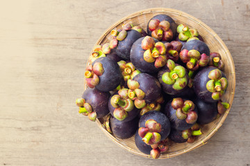 Fresh mangosteen in bamboo basket on wooden table. Healthy and sweet fruit. High vitamins.